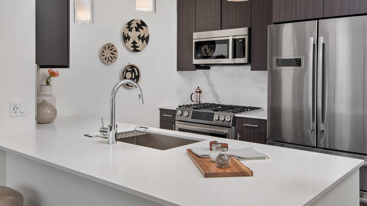 Stylish kitchen with quartz countertops, pendant lighting, and stainless steel appliances at 465 North Park apartments in Chicago