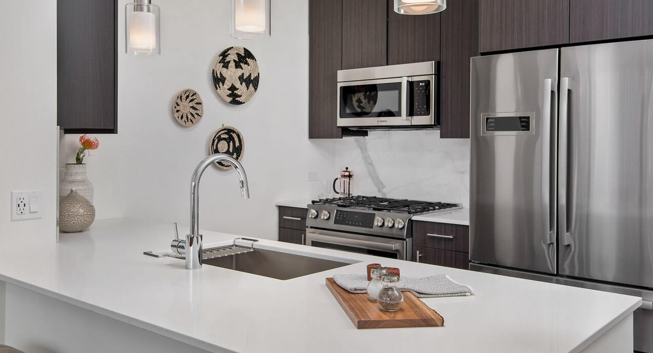 Stylish kitchen with quartz countertops, pendant lighting, and stainless steel appliances at 465 North Park apartments in Chicago
