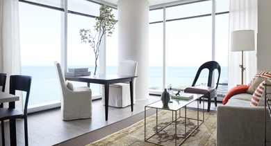 Bright living room with floor-to-ceiling windows, modern furniture, and lake views at 500 Lake Shore Drive apartments in Chicago