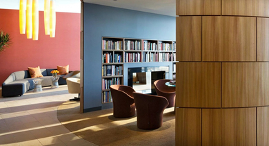 Cozy library lounge with built-in bookshelves, modern fireplace, and curved wood accents creating quiet reading spaces at 500 Lake Shore Drive in Chicago