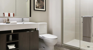 Spacious bathroom with glass shower, double sink vanity, and sleek finishes at 500 Lake Shore Drive apartments in Chicago