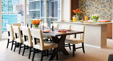 Elegant private dining room with large table, contemporary chandelier, and floor-to-ceiling windows facing the skyline near a serving bar at 500 Lake Shore Drive in Chicago