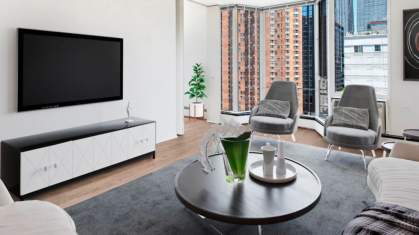 Corner living room with bay windows, gray lounge chairs, modern TV console, and skyline views at 55 West Chestnut apartments in Chicago