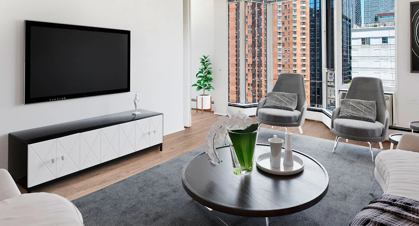 Corner living room with bay windows, gray lounge chairs, modern TV console, and skyline views at 55 West Chestnut apartments in Chicago