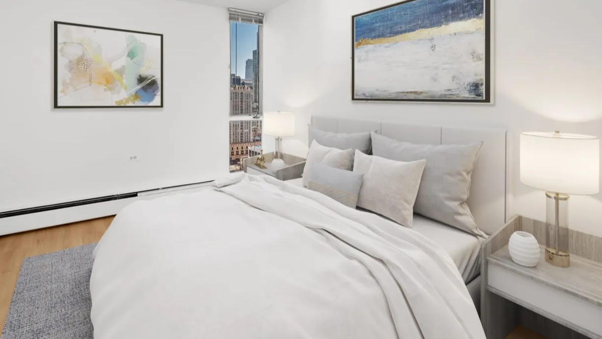 Cozy bedroom with soft neutral bedding, contemporary artwork, nightstands, and a tall window showcasing city views at 55 West Chestnut apartments in Chicago
