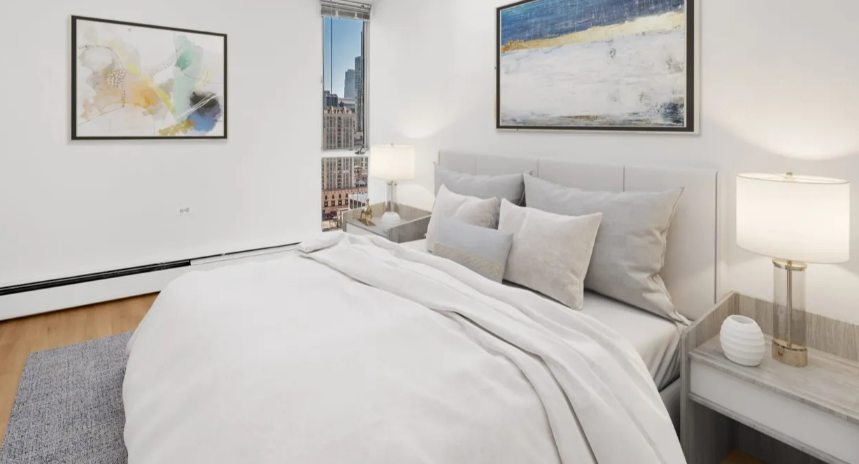 Cozy bedroom with soft neutral bedding, contemporary artwork, nightstands, and a tall window showcasing city views at 55 West Chestnut apartments in Chicago