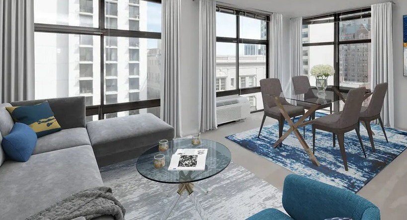 Corner living and dining area with floor-to-ceiling windows, modern furnishings, and city views at 65 East Scott apartments in Chicago