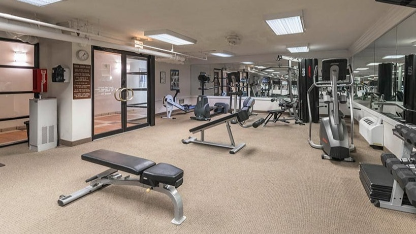 Resident fitness center with free weights, cable machines, bench, and cardio equipment at 65 East Scott apartments in Chicago