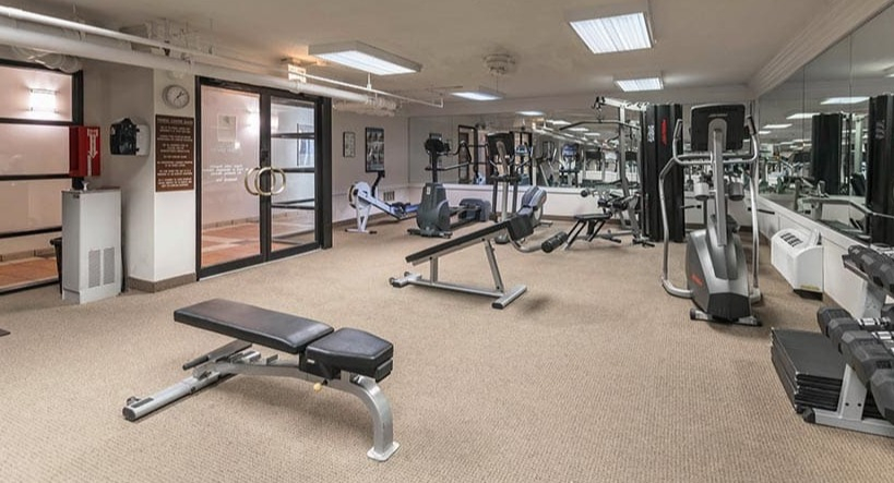 Resident fitness center with free weights, cable machines, bench, and cardio equipment at 65 East Scott apartments in Chicago