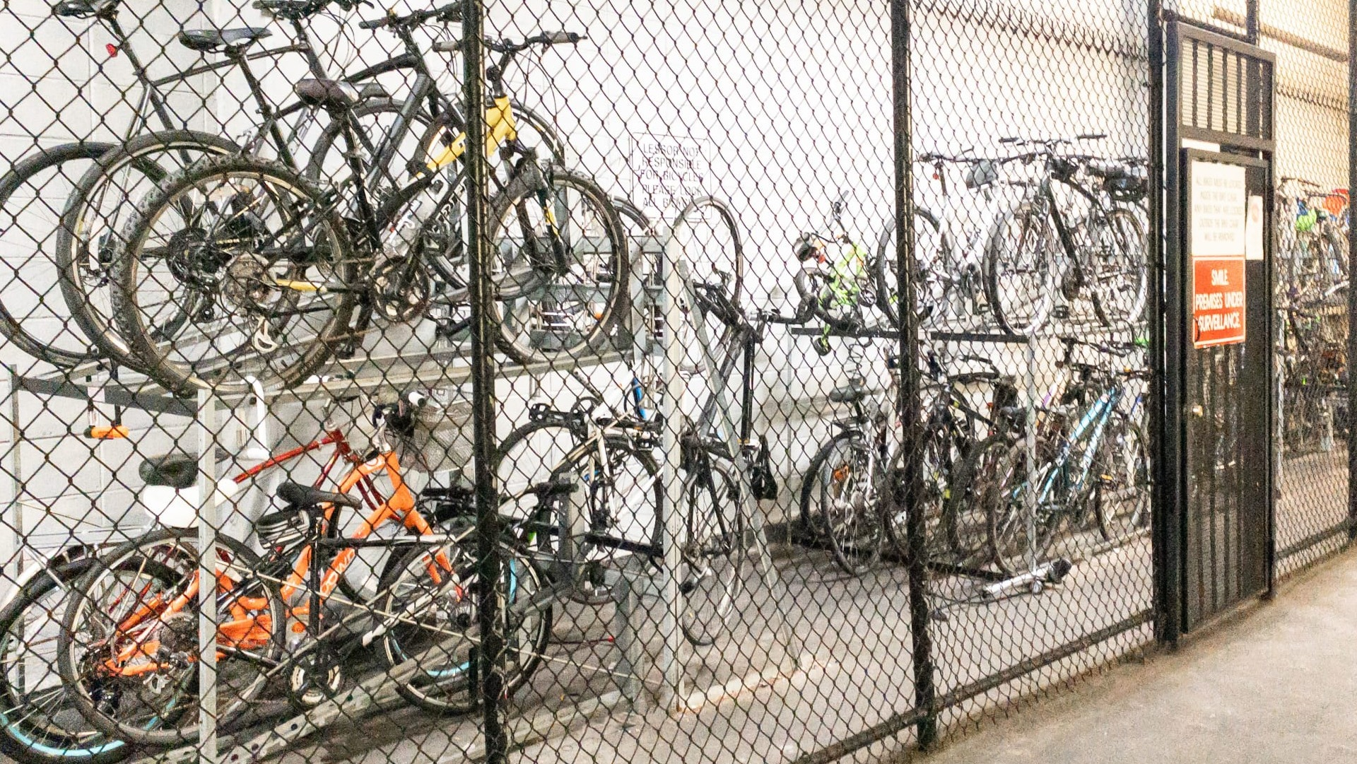 Secure indoor bike storage with two-level racks behind a locked gate for residents at 65 East Scott apartments in Chicago