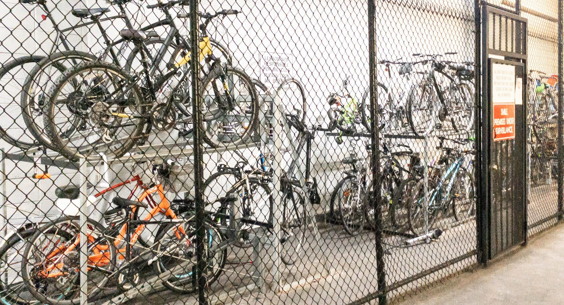 Secure indoor bike storage with two-level racks behind a locked gate for residents at 65 East Scott apartments in Chicago