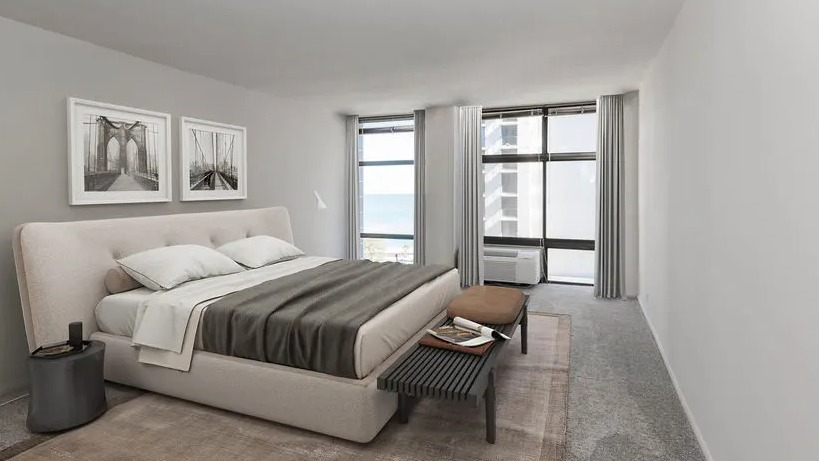 Spacious bedroom with large windows, lake glimpse, neutral decor, and carpeted flooring at 65 East Scott apartments in Chicago