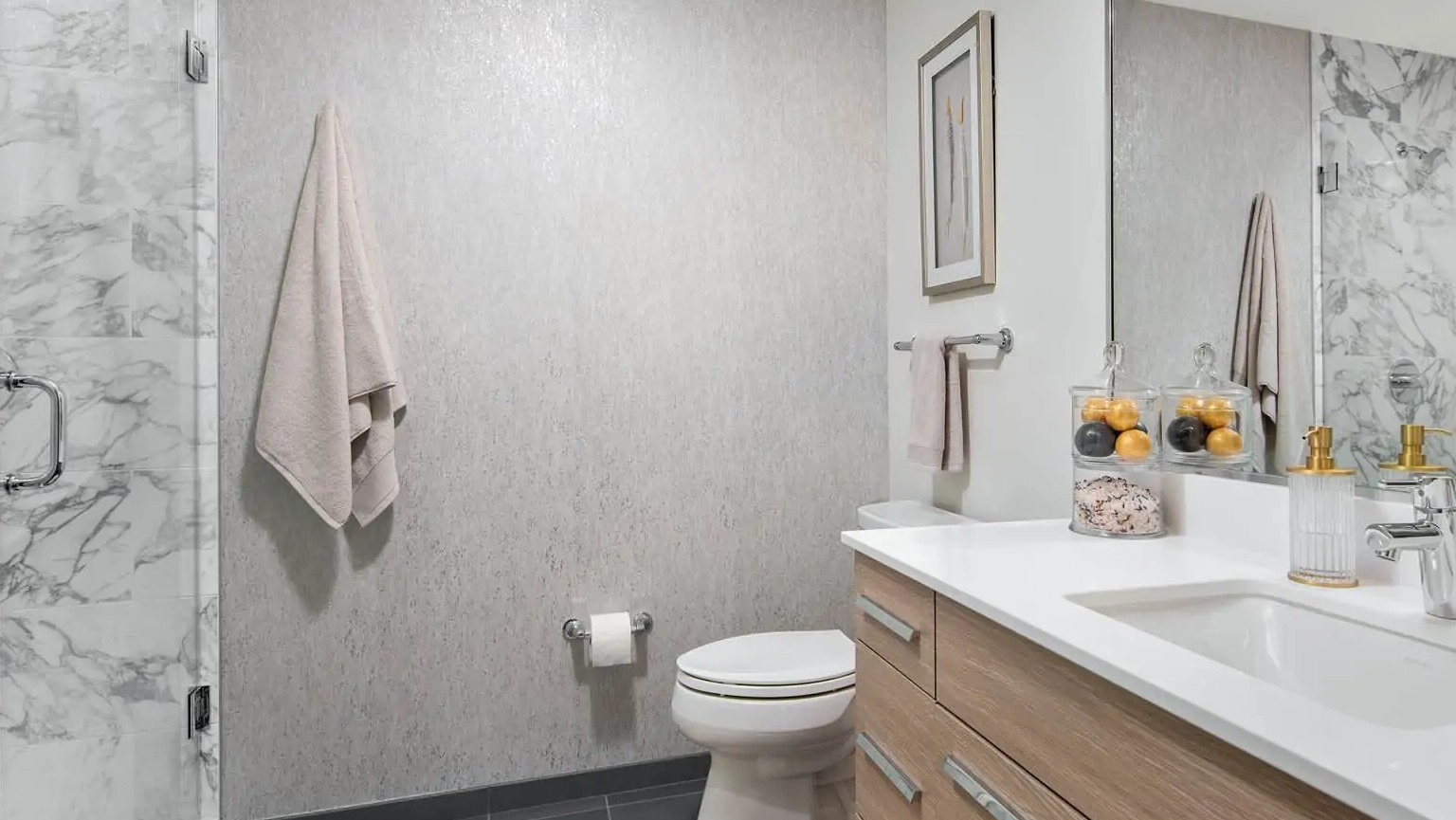Modern bathroom at 727 West Madison in Chicago featuring a frameless glass shower, marble wall tile, wide vanity, and sleek fixtures