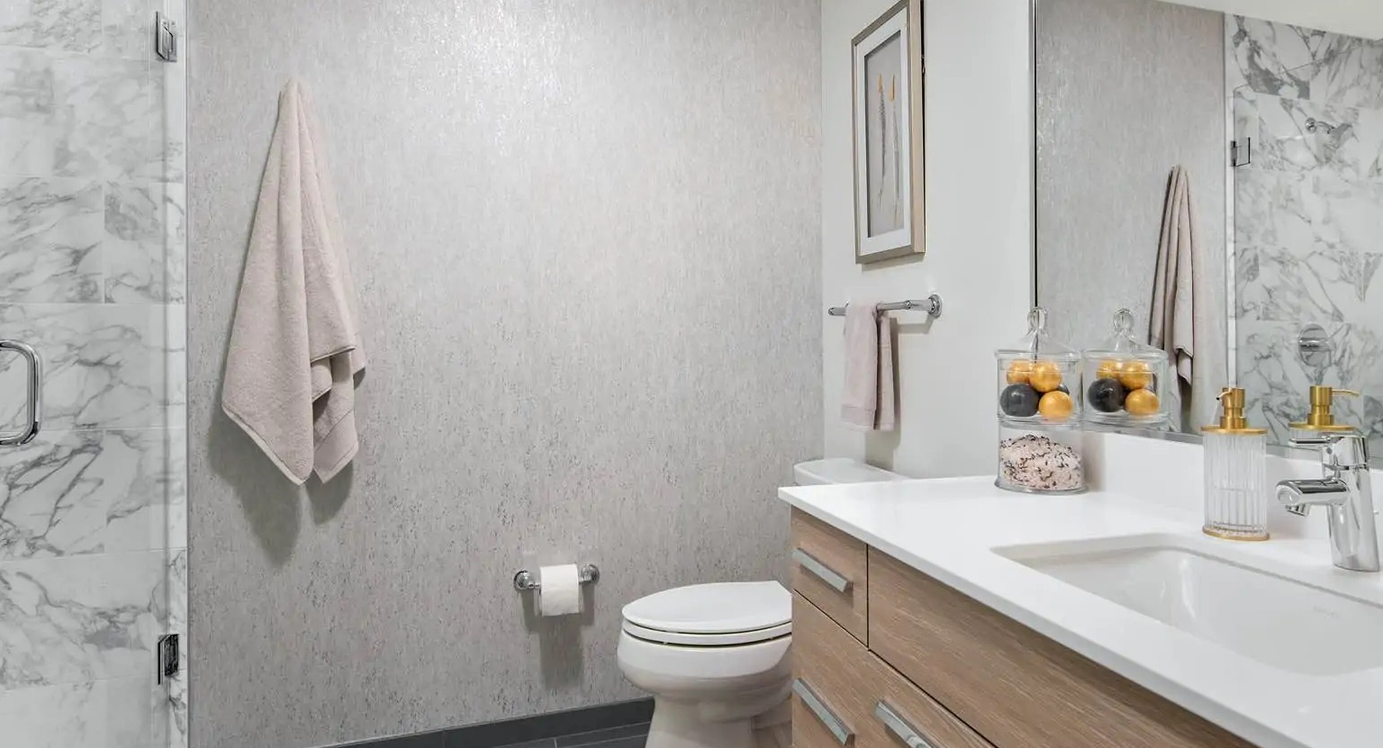 Modern bathroom at 727 West Madison in Chicago featuring a frameless glass shower, marble wall tile, wide vanity, and sleek fixtures