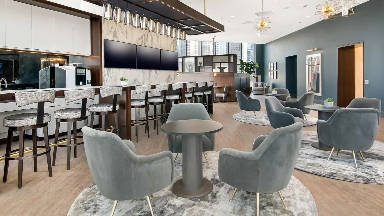 Chic coffee bar and social lounge at 727 West Madison, featuring marble accents, long bar seating, plush club chairs, and modern lighting in Chicago