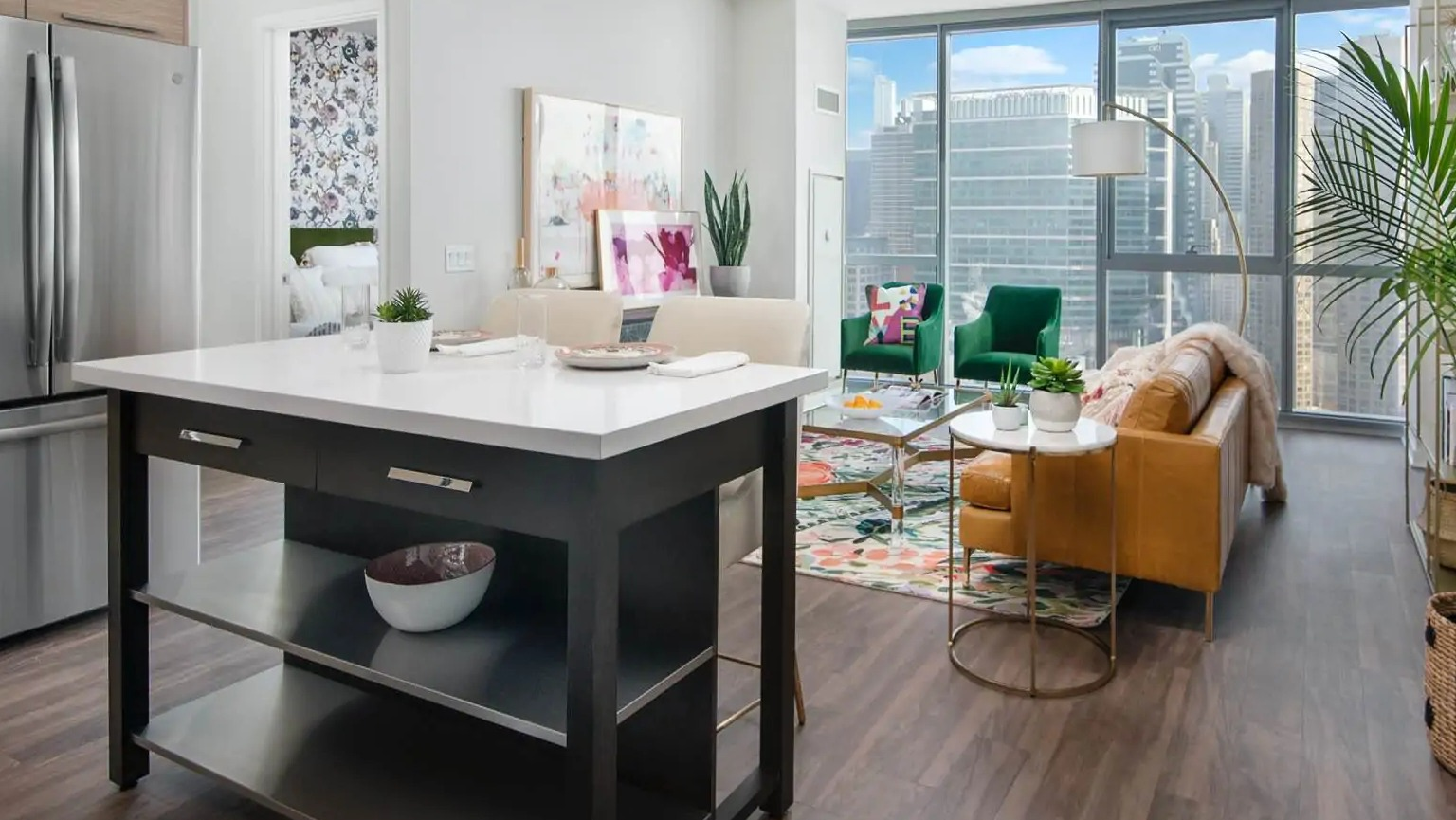 Open-concept living area at 727 West Madison in Chicago with island seating, chic décor, and expansive windows framing downtown views