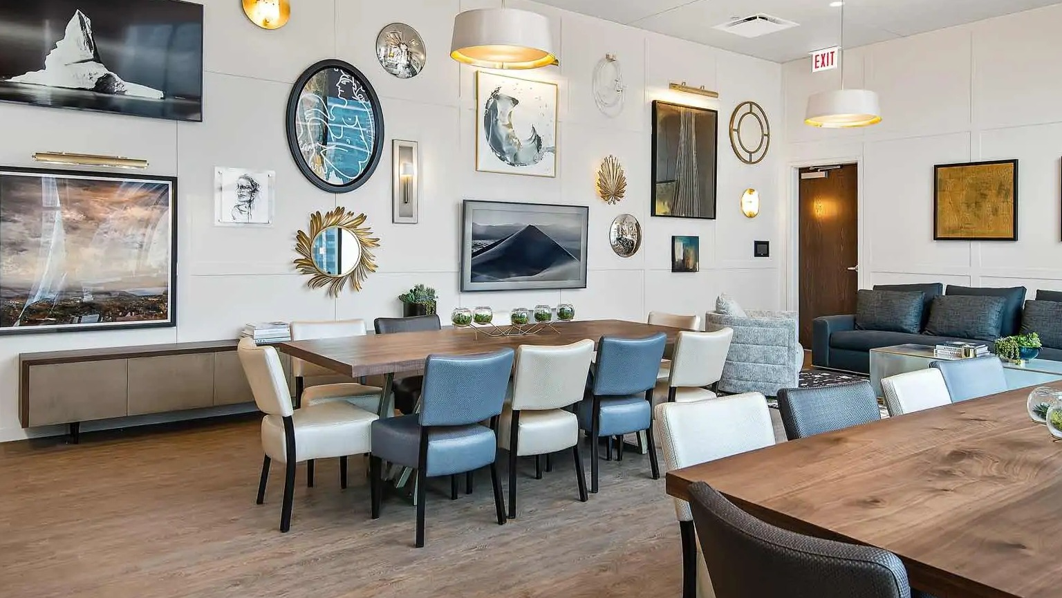 Elegant party room at 727 West Madison in Chicago, offering long dining tables, artwork-filled walls, and comfortable lounge seating for gatherings
