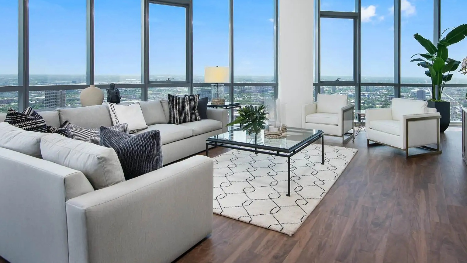 Studio apartment at 727 West Madison in Chicago with bed, sofa seating, tall windows, and open layout with skyline views