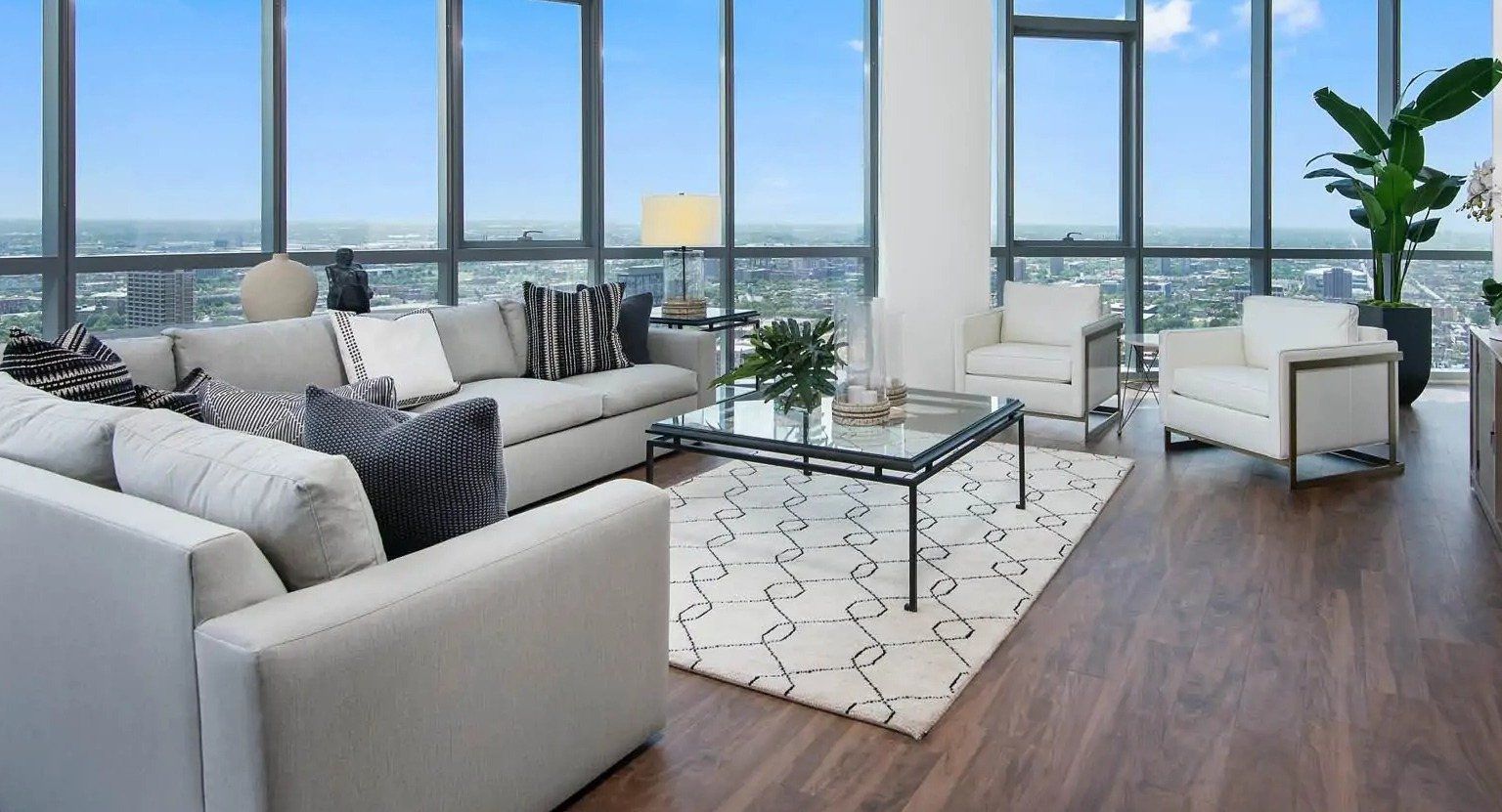 Studio apartment at 727 West Madison in Chicago with bed, sofa seating, tall windows, and open layout with skyline views