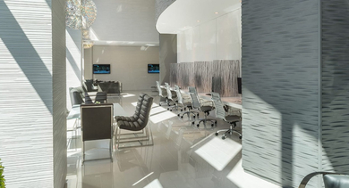 Bright business center with long workstations, ergonomic chairs, and tall windows at 73 East Lake apartments in downtown Chicago