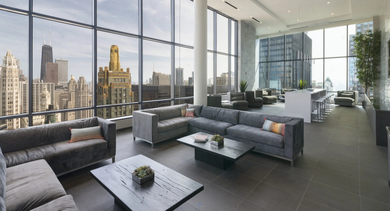 Penthouse sky lounge with floor-to-ceiling windows, plush seating, and sweeping skyline views at 73 East Lake apartments in Chicago