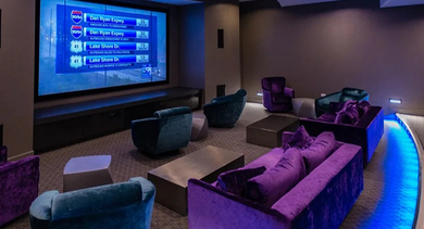 Private theater with oversized screen, plush club seating, and ambient LED lighting at 73 East Lake apartments in Chicago