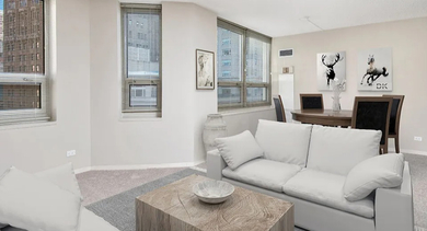 Cozy living room and dining nook with multiple corner windows and city views at 750 N Rush St apartments in Chicago, offering flexible furniture layout and natural light