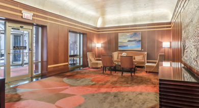 Welcoming lobby lounge at 750 N Rush St apartments in Chicago with warm wood paneling, comfy seating areas, soft lighting, and modern décor