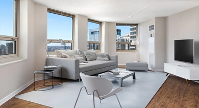 Open living room with sleek furniture, large windows, and city views at 750 N Rush St apartments in River North, Chicago—spacious layout for comfortable living