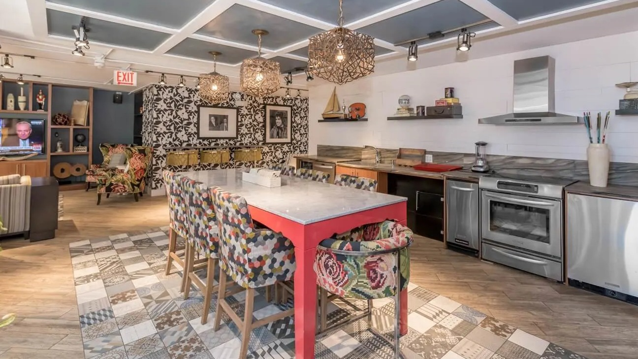 Community kitchen and dining space with pendant lighting, marble-topped island, and stainless appliances at 860 N Dewitt Apartments in Chicago