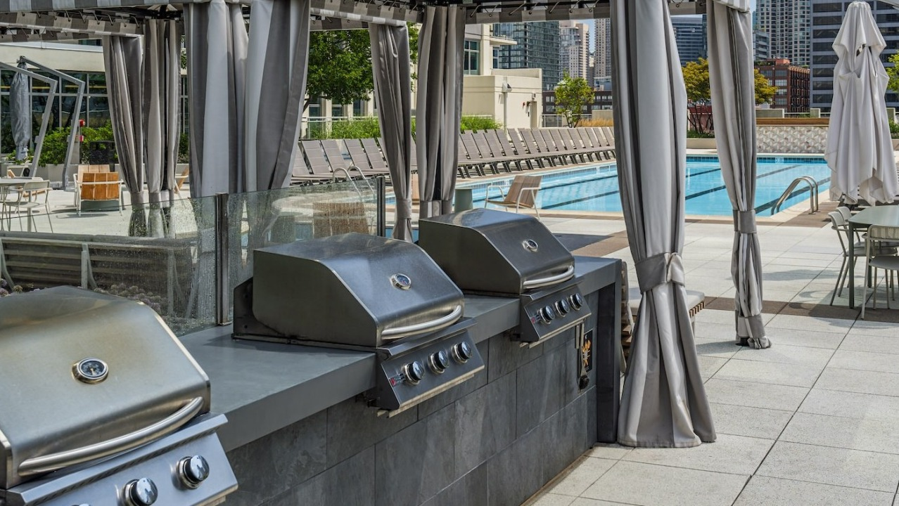 Rooftop grilling stations with stainless steel BBQs and shaded cabanas at Alta at K Station, perfect for entertaining with city views