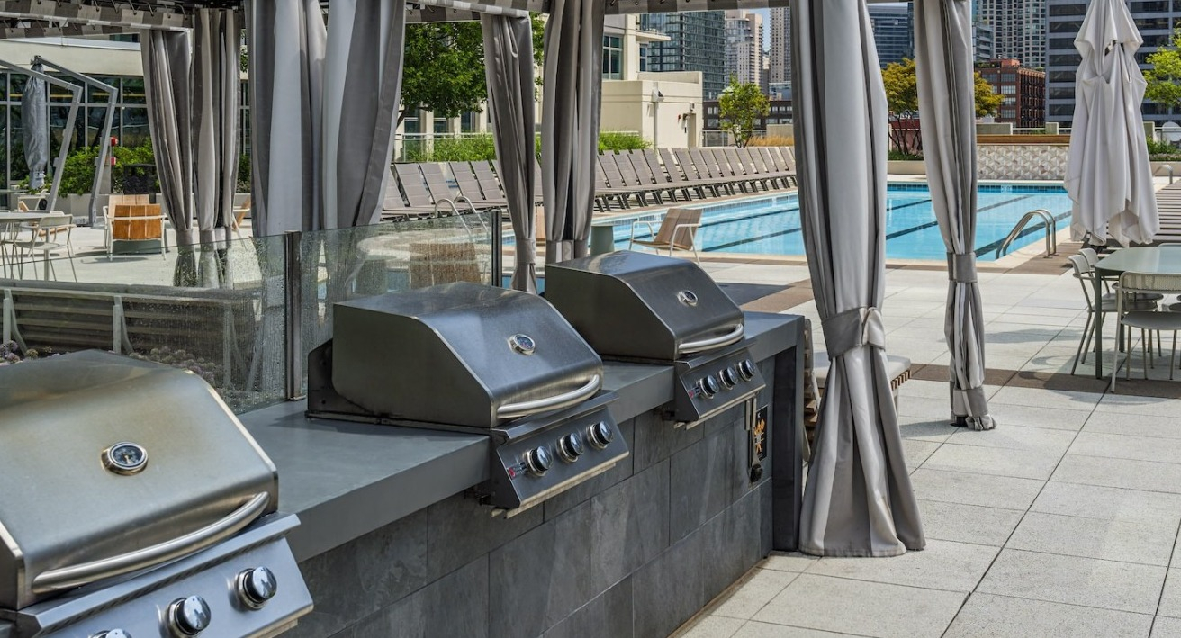 Rooftop grilling stations with stainless steel BBQs and shaded cabanas at Alta at K Station, perfect for entertaining with city views