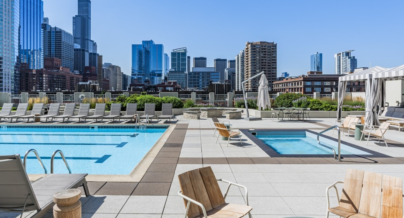 Rooftop swimming pool and spa at Alta at K Station with lounge chairs and skyline views, offering resort-style amenities in downtown Chicago apartments