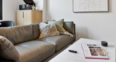 Cozy living room with modern sofa, large windows, and open-concept layout at AMLI 808 apartments in Chicago, perfect for relaxing or entertaining
