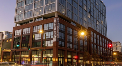 AMLI 808 apartments in Chicago exterior at night with illuminated facade and street presence, highlighting a prime location and modern architecture