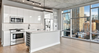 Modern kitchen with quartz counters, stainless steel appliances, and island seating at AMLI 808 apartments in Chicago for easy cooking and hosting