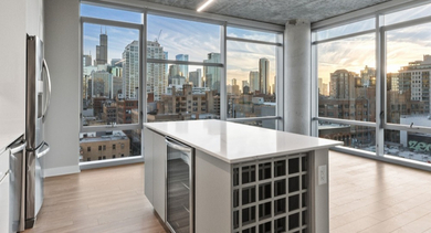 Open-concept kitchen with island seating at AMLI 808 in Chicago, with stainless appliances and space to cook, dine, and gather