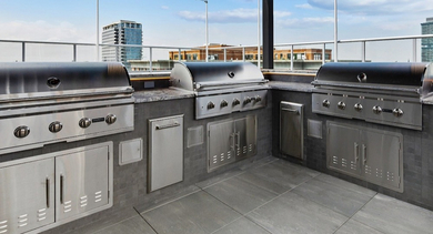 Outdoor grill station with stainless cooktops, dining areas, and seating at AMLI 808 in Chicago—great for weekend cookouts with neighbors
