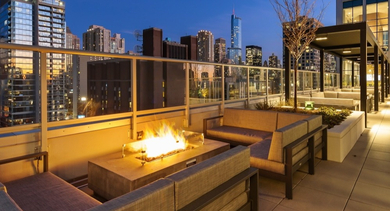 Rooftop deck at AMLI 808 in Chicago with skyline views at night, lounge seating, and ambient lighting for sunsets and city gatherings