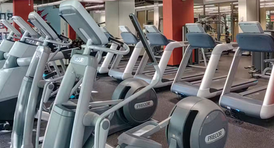 Spacious fitness center at AMLI 900 featuring Precor treadmills, ellipticals, mirrors, and bright lighting for convenient on-site workouts in Chicago