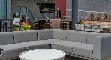 Rooftop terrace at AMLI 900 offering sectional seating, dining areas, planters, and striking downtown Chicago skyline views for relaxed outdoor lounging