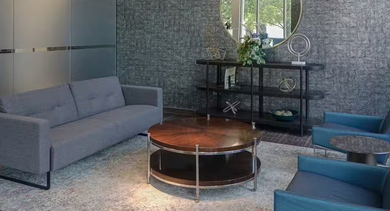 Inviting lobby at AMLI 900 with a gray sofa, teal lounge chairs, round wood coffee table, large windows, and modern décor creating a welcoming entry in Chicago