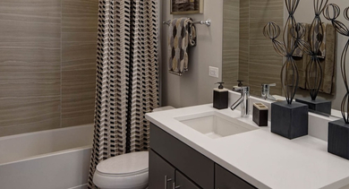 Modern bathroom featuring a double vanity, stylish fixtures, and a shower/tub combination at AMLI Lofts in Chicago
