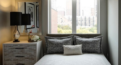 Cozy bedroom featuring a comfortable bed, stylish nightstand, and a large window with city views at AMLI Lofts