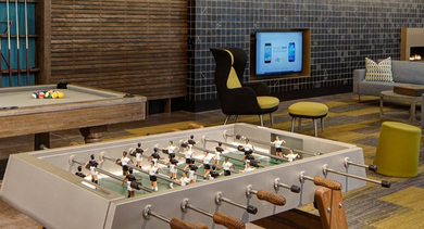 Spacious game room featuring a billiards table, foosball table, and comfortable lounge seating at AMLI Lofts in Chicago
