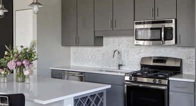 Contemporary kitchen with gray cabinets, white countertops, and stainless steel appliances at AMLI Lofts in Chicago
