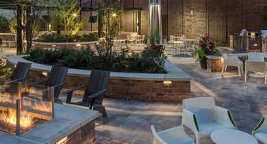Beautifully lit outdoor lounge area with a cozy fire pit and ample seating for residents at AMLI Lofts in Chicago