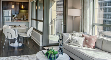 Bright apartment at AMLI River North, showcasing an open living and dining area with access to a private balcony