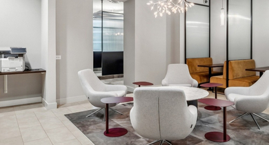 Modern business center at AMLI River North with computers, printer access, and collaborative lounge seating for residents