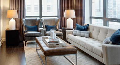 Cozy living room at AMLI River North with comfortable seating, modern decor, and large windows offering city views